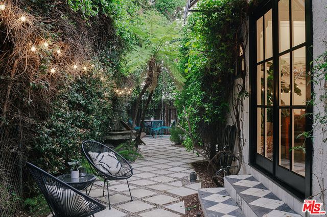 a view of backyard with seating and trees