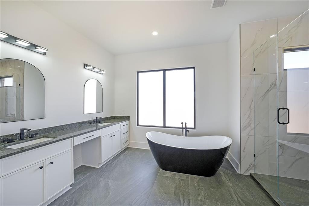 156 Rocky Ridge Way Auburn, GA 30011 - Photo 36 of 56 a spacious bathroom with a double vanity sink a mirror and a bathtub