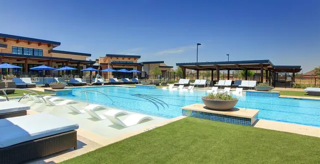 a swimming pool with outdoor seating and a garden