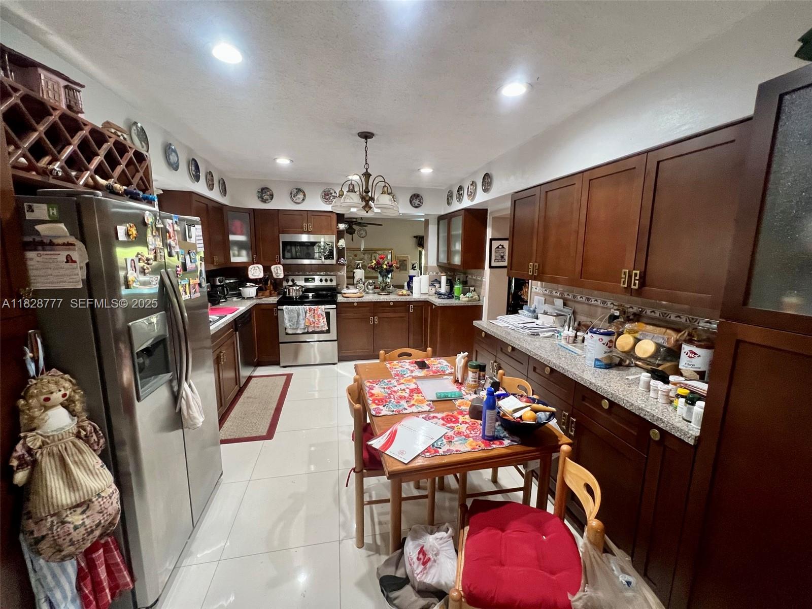 9601 Southwest 66th Street Miami, FL 33173 - Photo 10 of 52 a kitchen with stainless steel appliances kitchen island granite countertop a stove refrigerator and cabinets