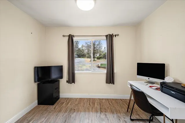 a room with stainless steel appliances wooden floor and a window
