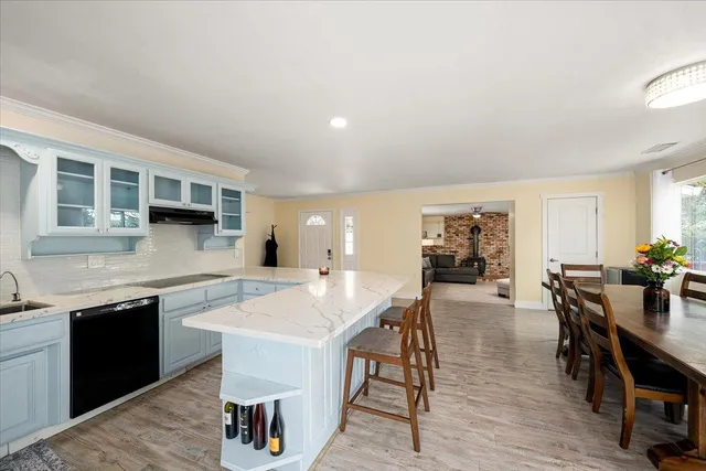 a view of a livingroom with a chandelier fan and windows