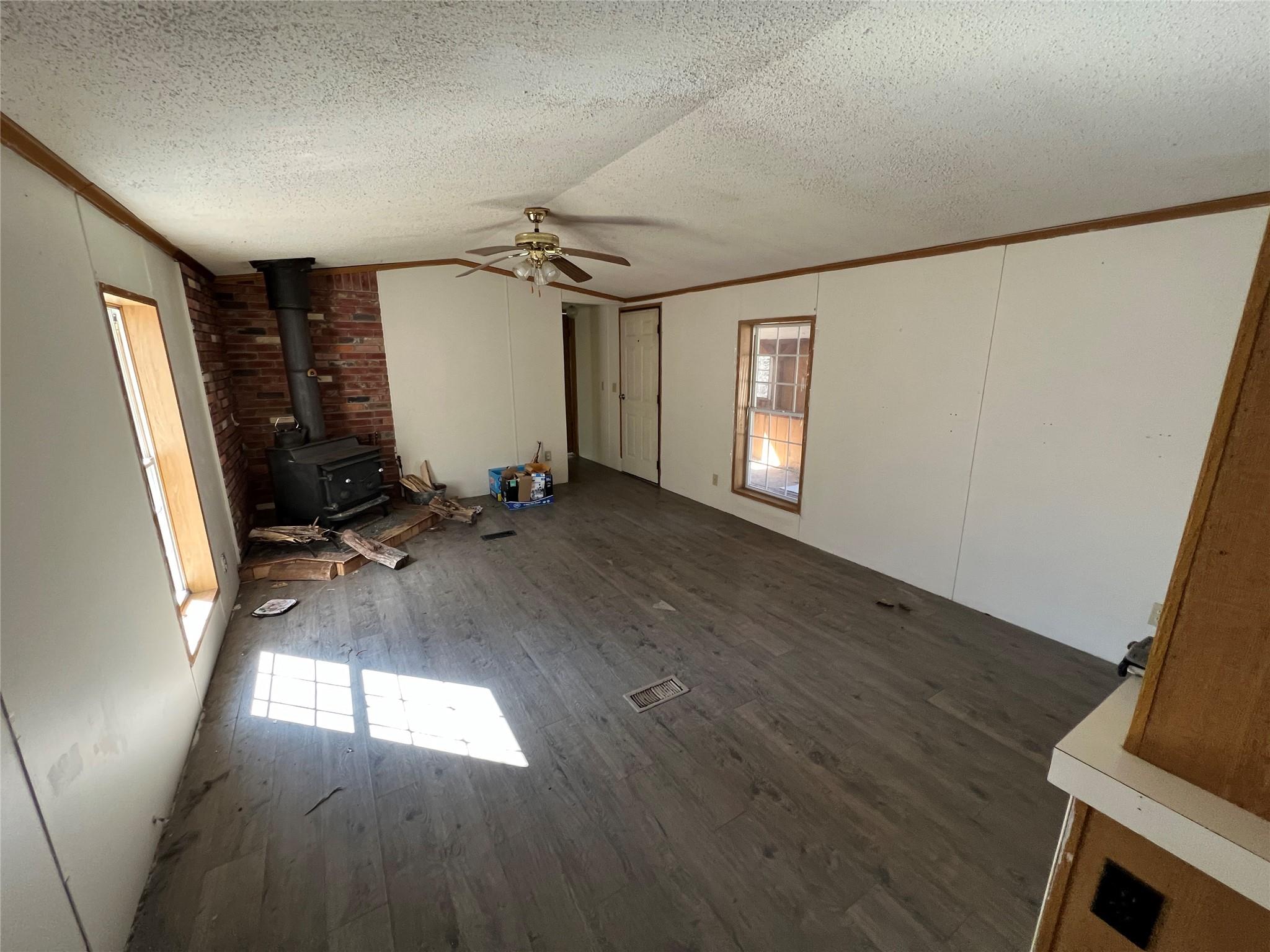 734 Shaver Hollow Road Andes, NY 13731 - Photo 7 of 9 Unfurnished living room with crown molding, a textured ceiling, ceiling fan, and wood finished floors