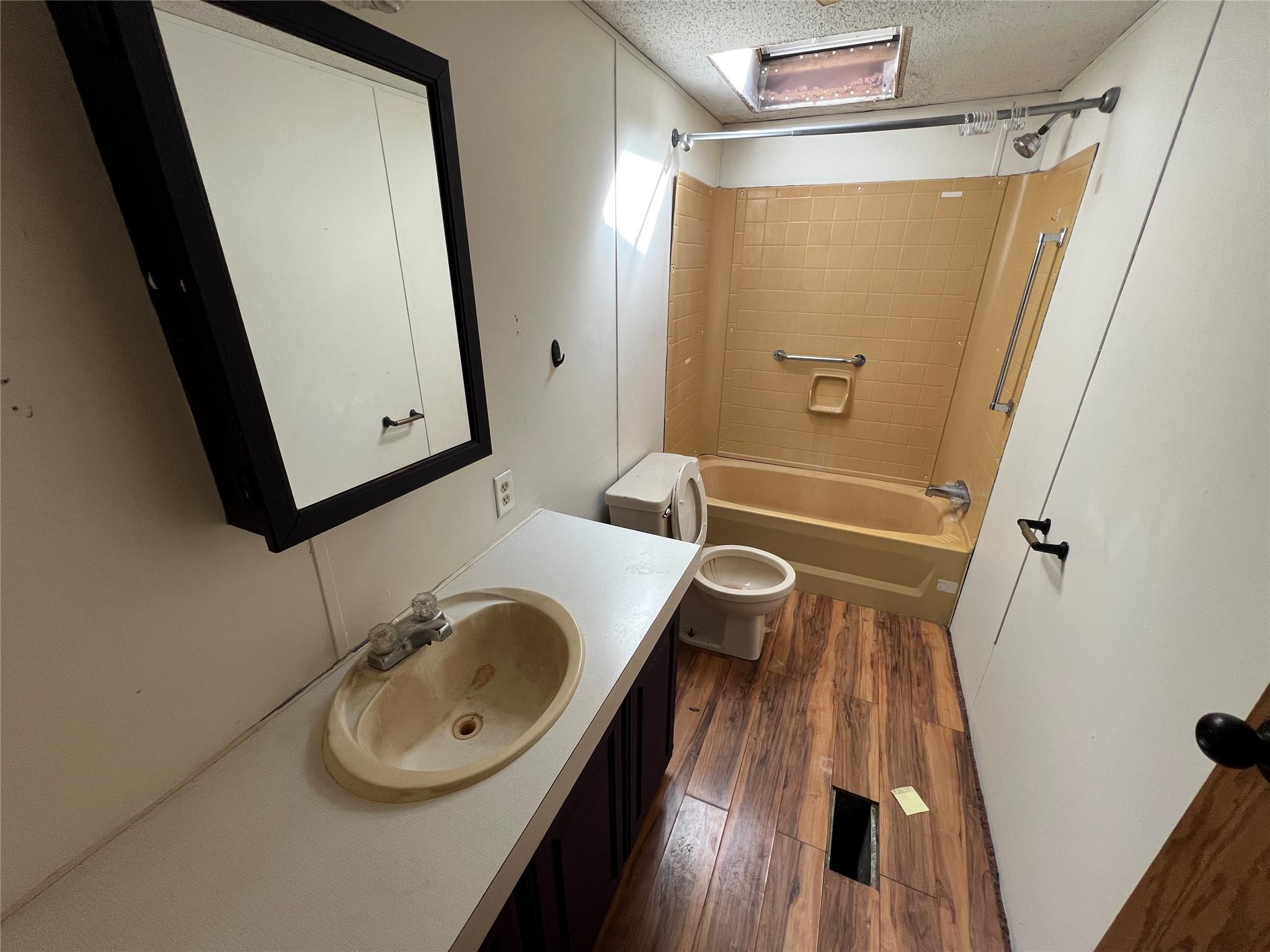 734 Shaver Hollow Road Andes, NY 13731 - Photo 8 of 9 Bathroom featuring toilet, wood finished floors, vanity, a textured ceiling, and bathtub / shower combination