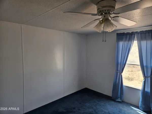 a view of room with a window and a ceiling fan