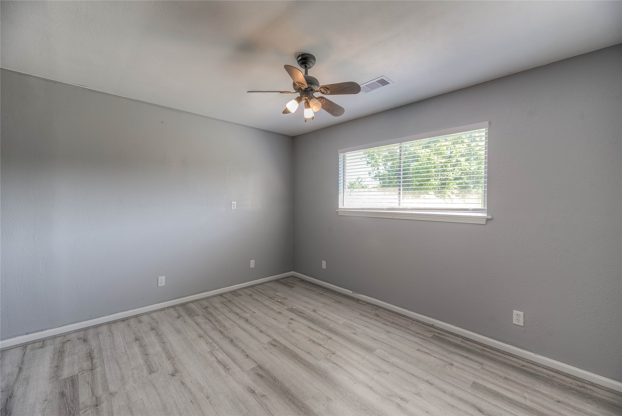 134 Deer Run Road Trinity, TX 75862 - Photo 18 of 21 an empty room with wooden floor ceiling fan and windows