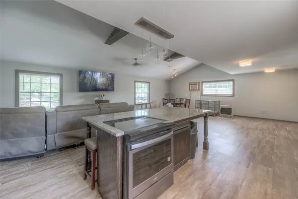 a kitchen with a stove a sink and a wooden floor
