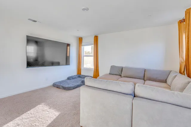 a living room with furniture a rug and white walls