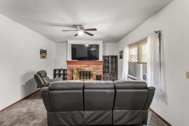 a living room with furniture a flat screen tv and a window