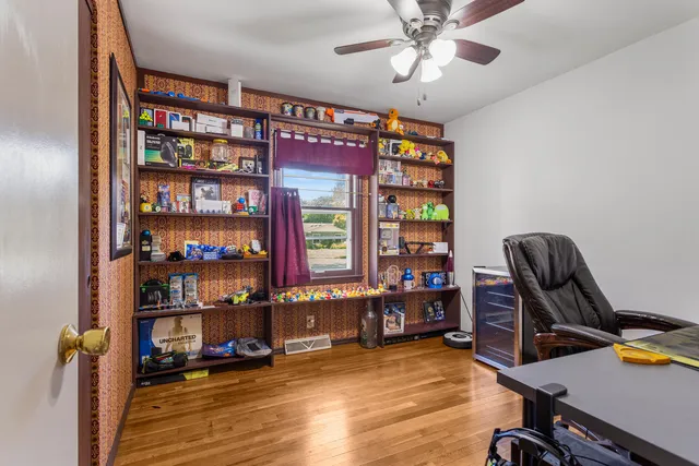 a view of a workspace with bookshelf and a window