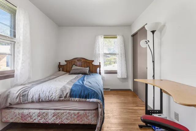 a bedroom with a bed window and wooden floor