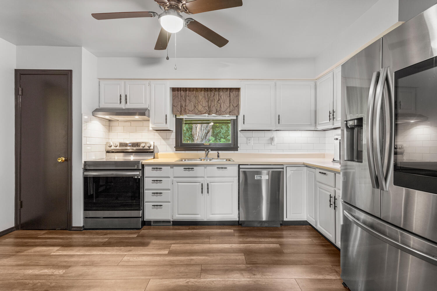 2305 East Shurts Circle Urbana, IL 61801 - Photo 6 of 26 a kitchen with a stove white cabinets and stainless steel appliances