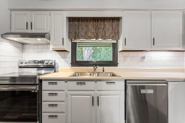 a kitchen with a sink stove and cabinets