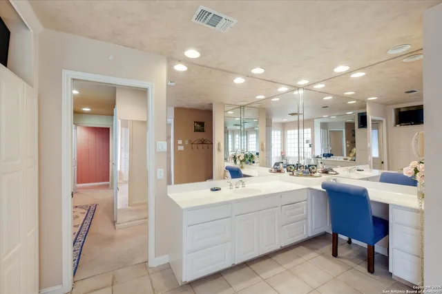 a large white kitchen with a white countertops a sink and appliances