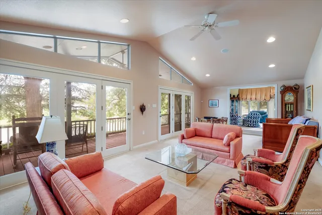 a living room with furniture a ceiling fan and a floor to ceiling window