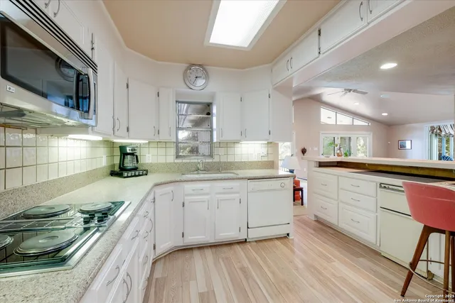 a kitchen with sink stove and cabinets
