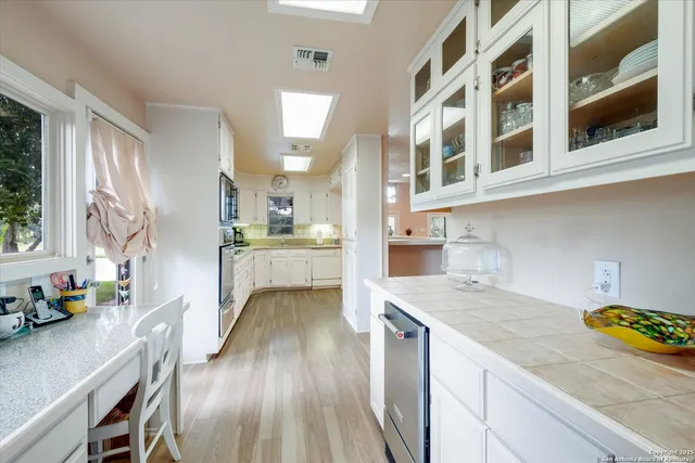 a kitchen with a wooden floor and cabinets