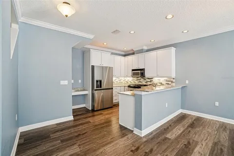 a kitchen with a refrigerator and a stove top oven