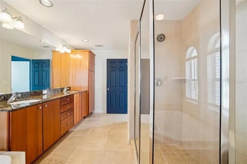 a large bathroom with a glass shower door and a sink