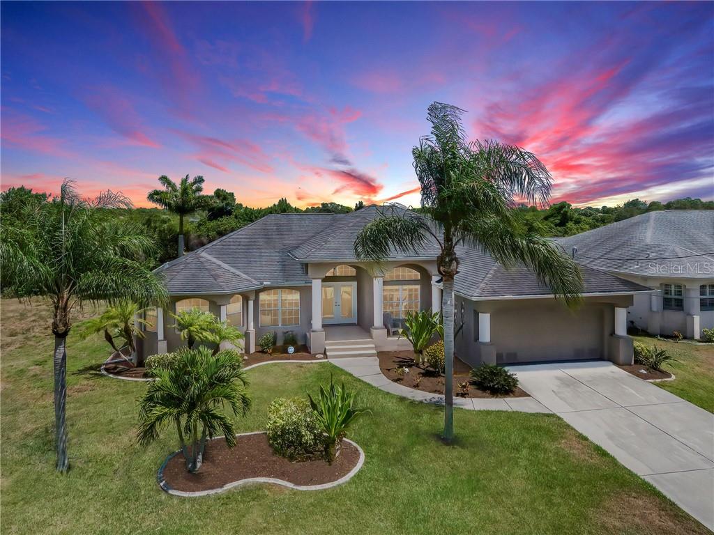 228 Tournament Road Rotonda West, FL 33947 - Photo 1 of 1 a front view of a house with a garden and a fire pit