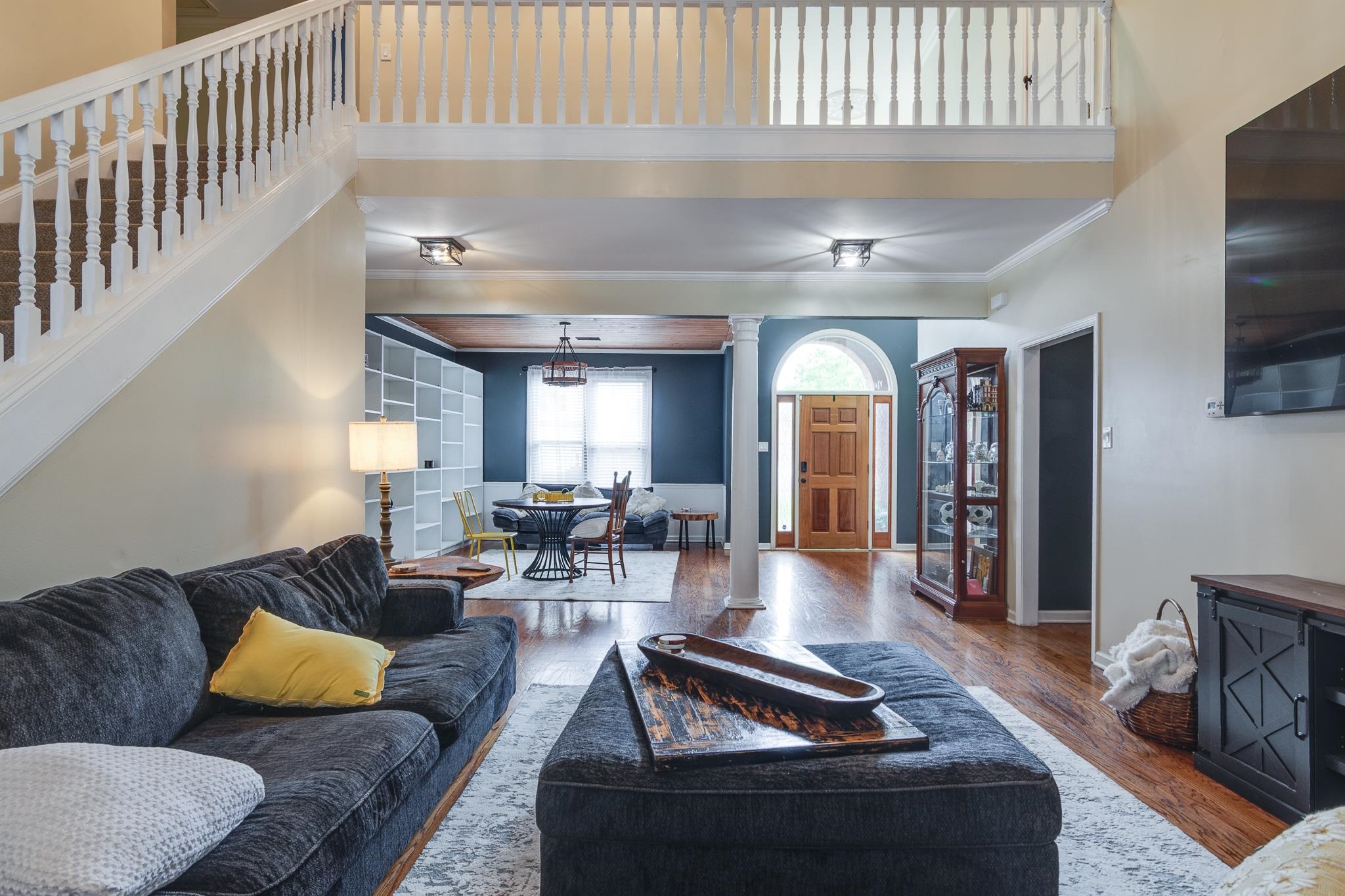 779 Early Earner Cove Collierville, TN 38017 - Photo 5 of 29 Two-story living area with wood-finish flooring, a grand staircase, and an arched entry door