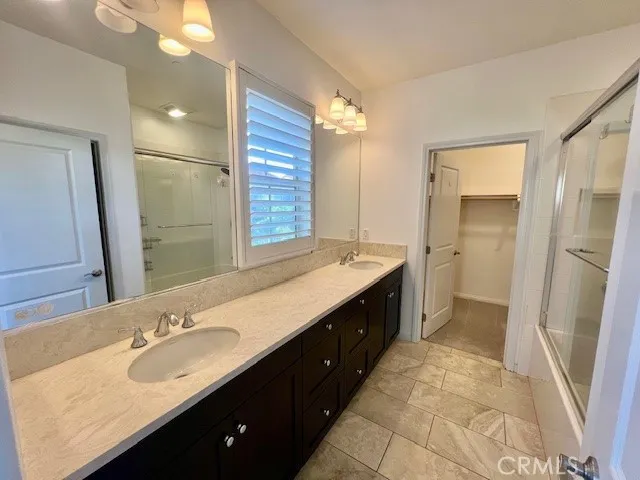 a bathroom with a double vanity sink a mirror and a shower