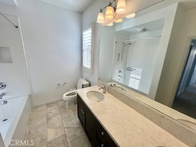 a bathroom with a granite countertop sink a toilet and bathtub