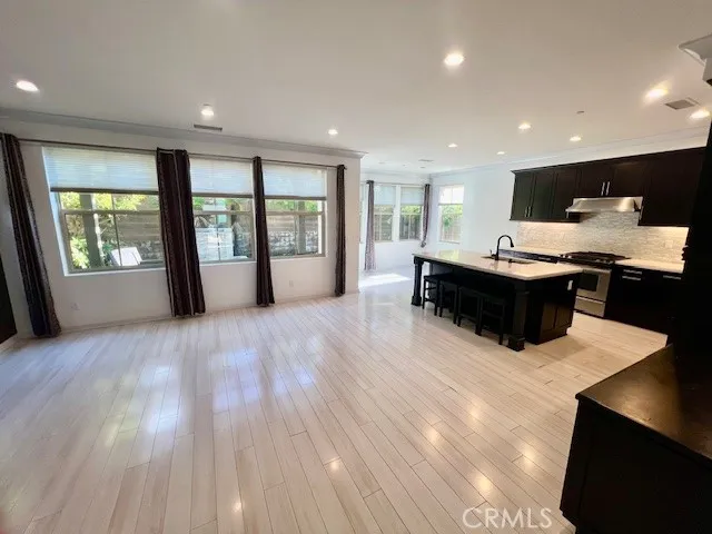 a living room with furniture a large window and wooden floors