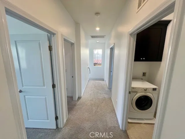 a view of a hallway with washer and dryer