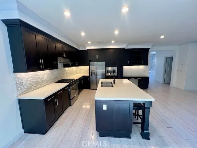 a large kitchen with stainless steel appliances a large counter top and oven