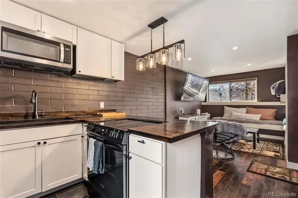 a kitchen with stainless steel appliances granite countertop a sink stove and cabinets