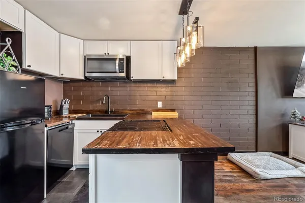 a kitchen with a sink a microwave and cabinets
