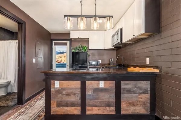 a kitchen view with granite countertop a sink a stove and a wooden floors