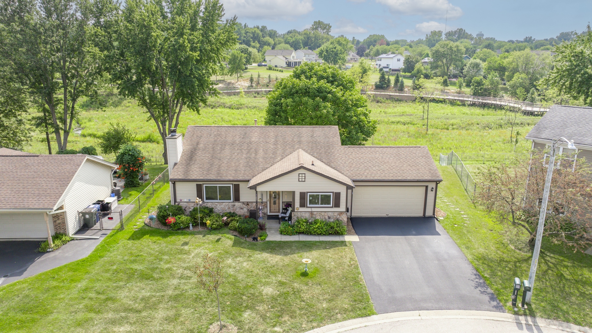 1151 Sandpebble Circle Algonquin, IL 60102 - Photo 1 of 34 a aerial view of a house next to a yard with plants and large trees