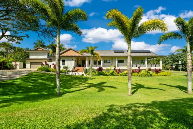 a view of a house with a big yard plants and large trees