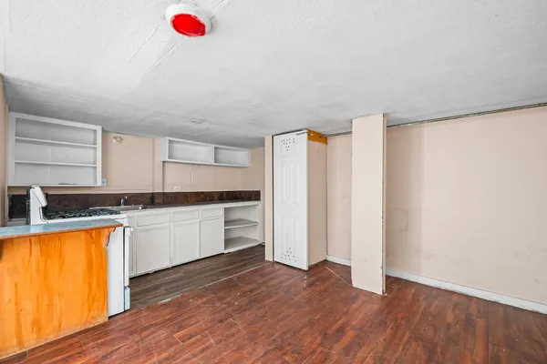 a kitchen with granite countertop a sink a stove and cabinets