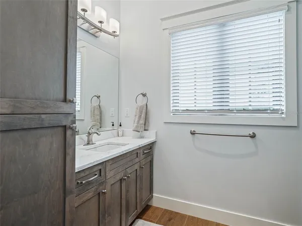 a bathroom with a granite countertop toilet sink and mirror