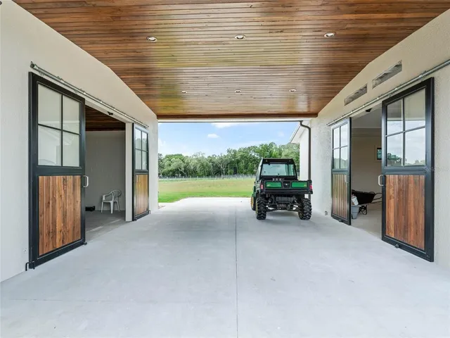 an aerial view of a swimming pool with a yard and plants