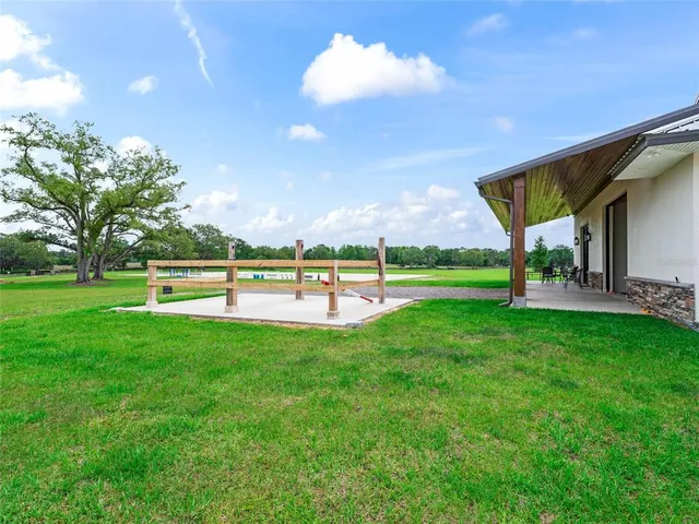 a view of a garden with lawn chairs and a swimming pool