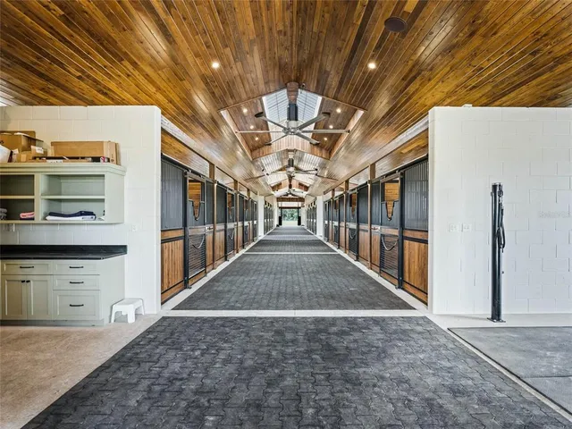 a kitchen with stainless steel appliances granite countertop a refrigerator a stove and white cabinets with wooden floors