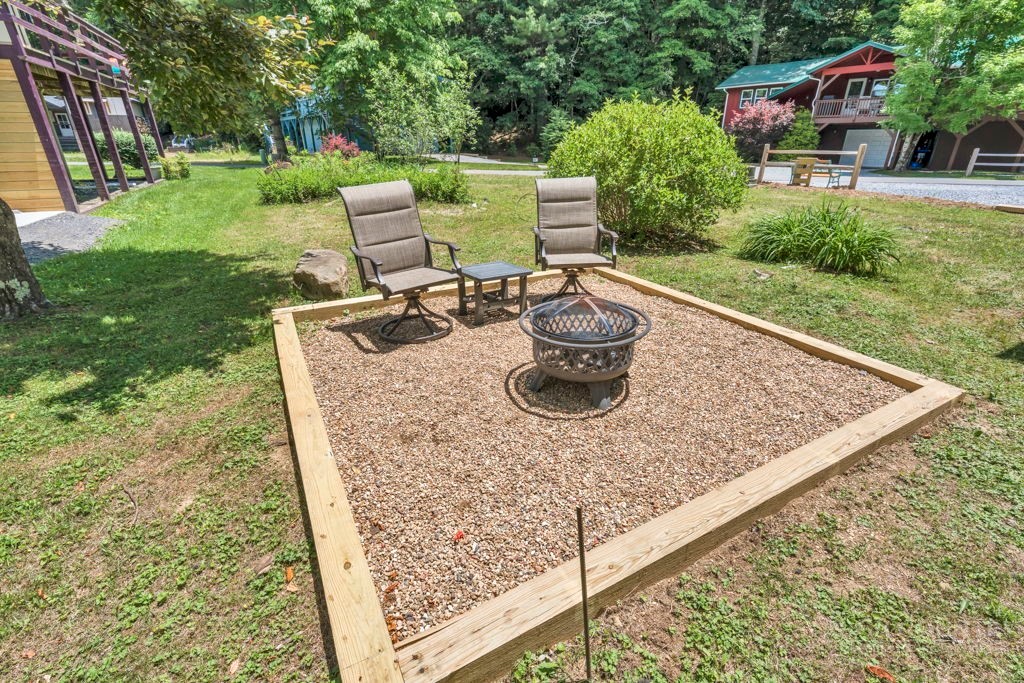 209 Meadow Loop Newland, NC 28657 - Photo 5 of 30 a view of a backyard with table and chairs potted plants and wooden fence