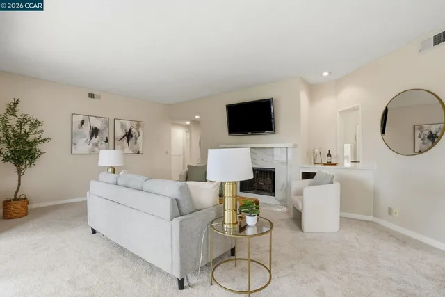 a living room with furniture a mirror and a flat screen tv