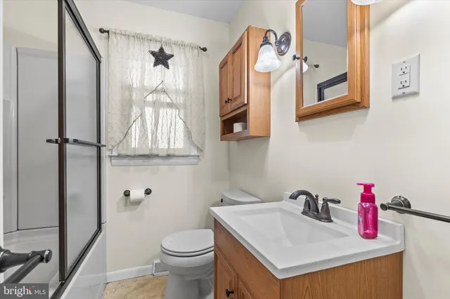 a bathroom with a sink vanity mirror and toilet
