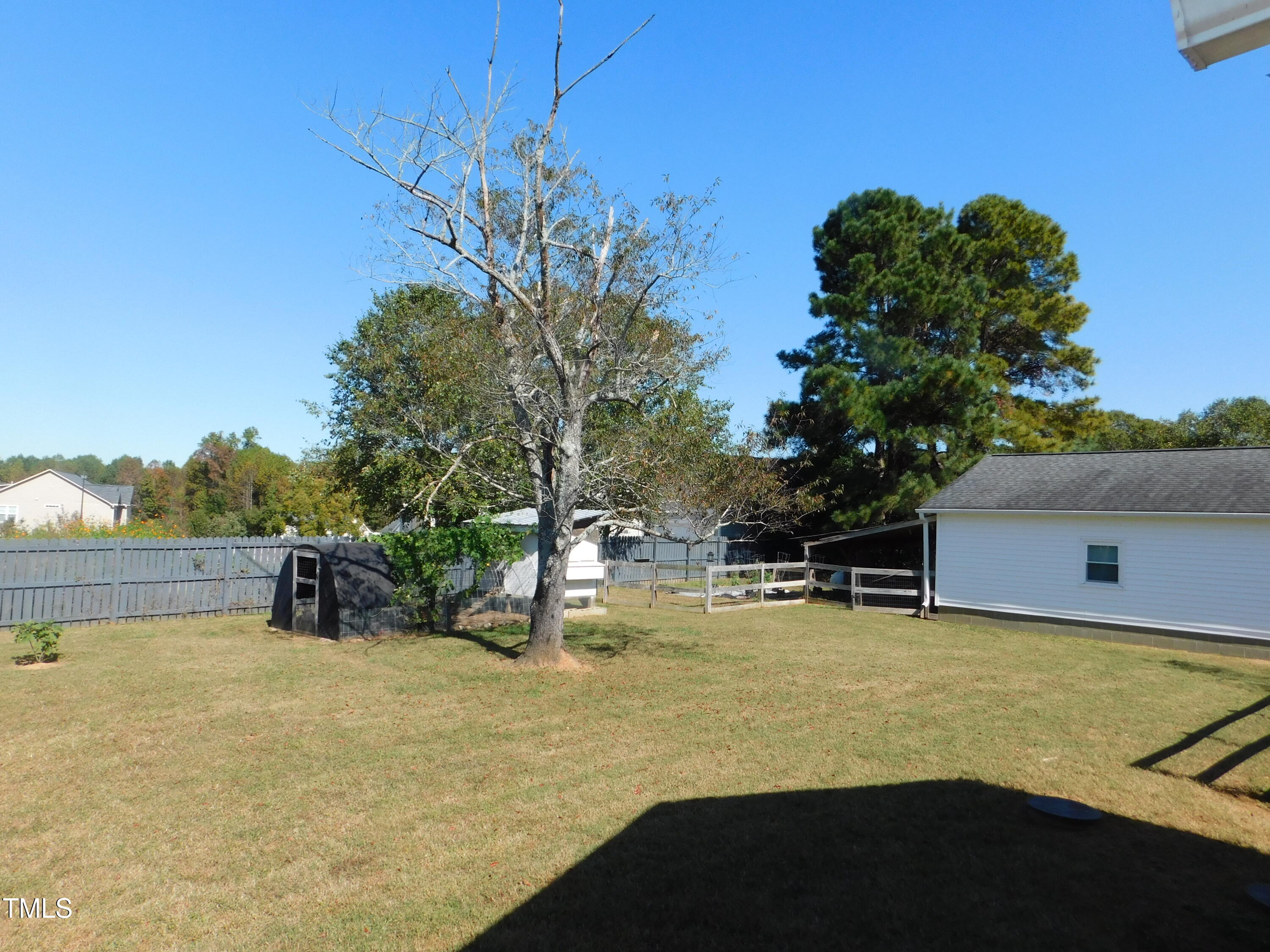 1168 Earpsboro Road Zebulon, NC 27597 - Photo 21 of 25 a view of a swimming pool with a bench and trees in the background