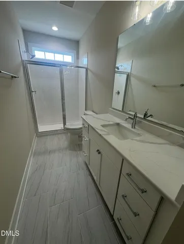 an empty room with a window and chandelier fan