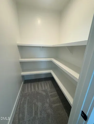 an empty room with a window and chandelier fan