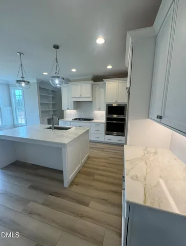 a large kitchen with a lot of counter space and a wooden floor