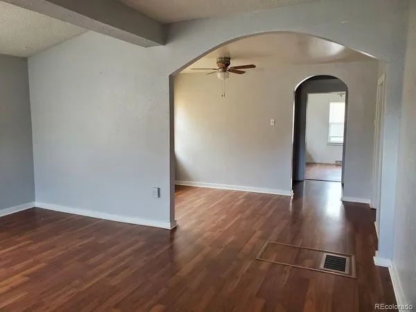 an empty room with wooden floor and entrance