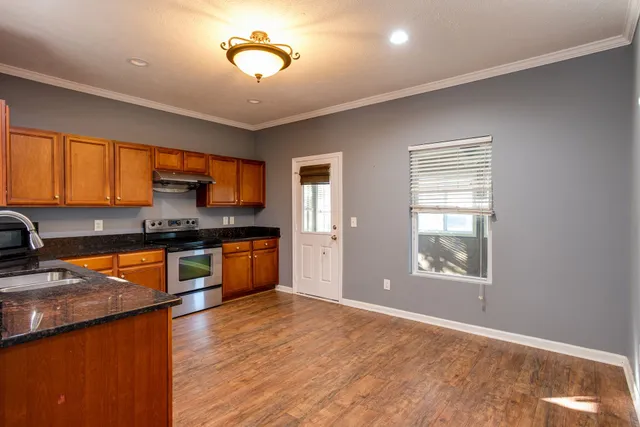 a kitchen with stainless steel appliances granite countertop a stove a sink and a refrigerator