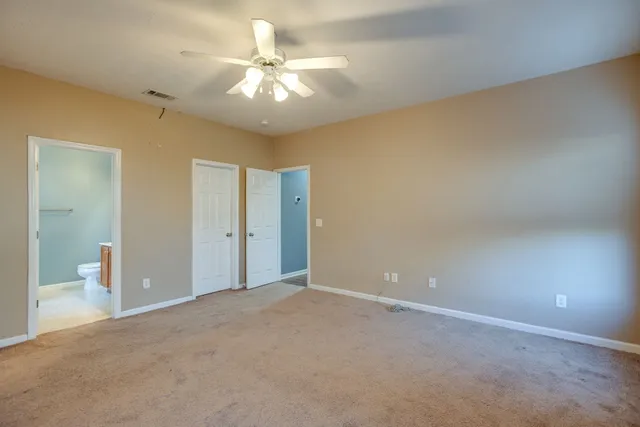a view of an empty room with a chandelier fan